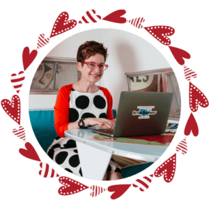 Beth Lennon sits in a vintage trailer, wearing a white dress with big black polka dots and a red sweater. Her laptop is open in front of her so she can share all her insights.