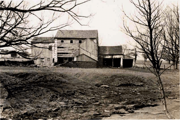 black and white photo of dilapidated barn buildings