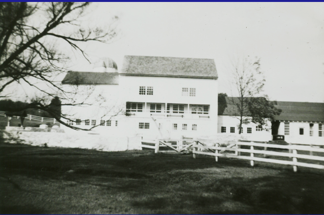 Black and white photo now shows the barn has windows on the upper story and bays in the facade of the lower floor