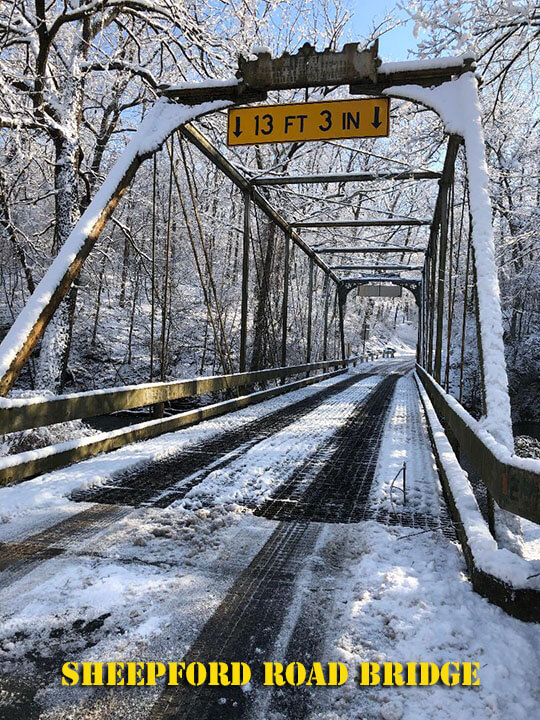 A metal bridge with its tracery details with a coating of snow