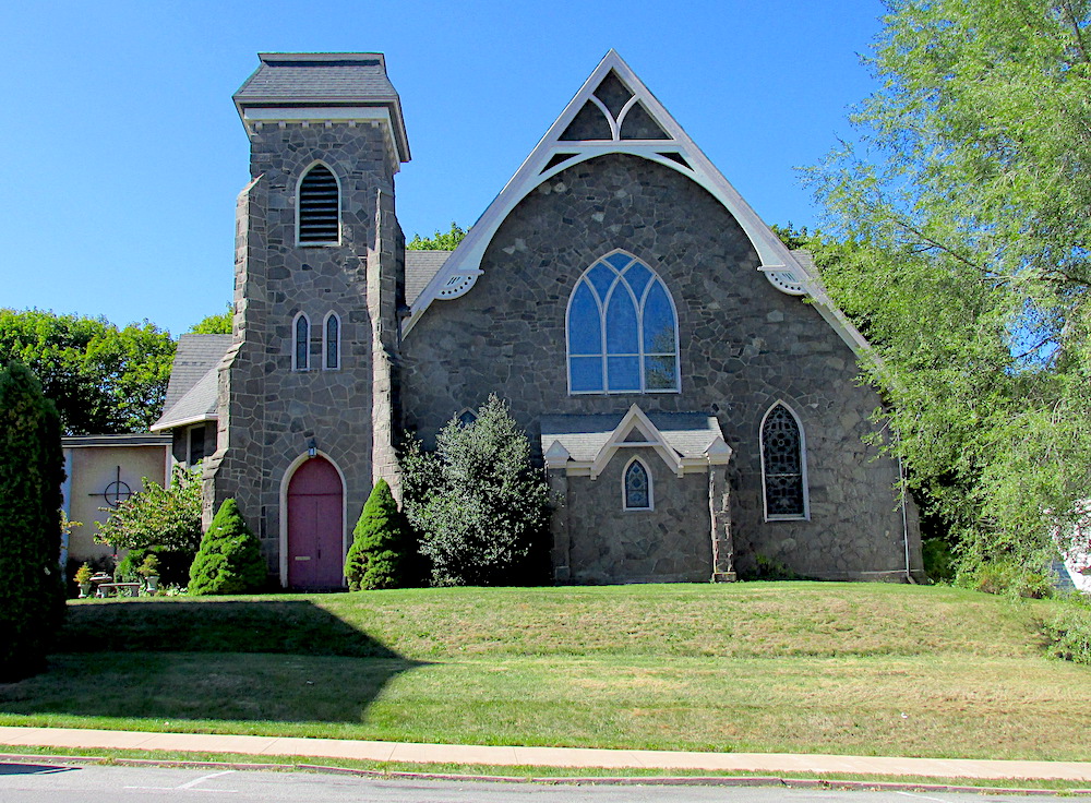 First Presbyterian Church is a grey stone gothic style chapel with a tower at the left