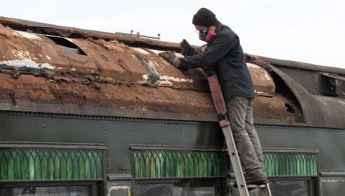 Removing old roofing from a historic railcar
