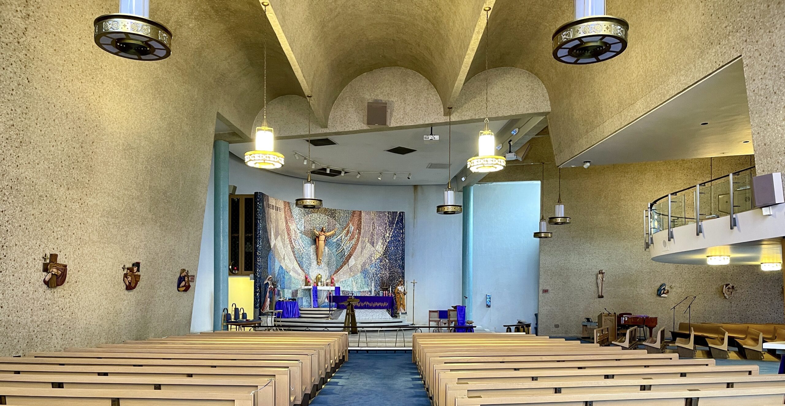 interior of the church shows the barrel vaulting, and the mosaic reredos screen behind the altar