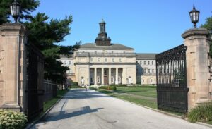Two gateposts frame St Charles Borromeo Seminary that includes a tower on top