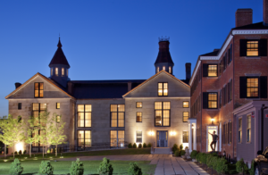 Twilight view of the rehabbed Old Salem Jail courtyard, windows lit, with small cupolas along the roofline