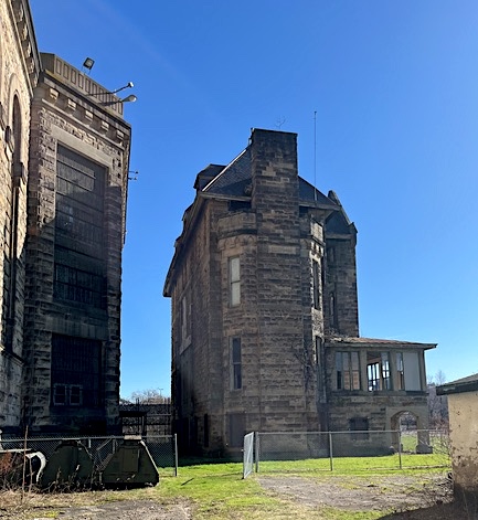 The prison walls on the left tower over the 4.5 story Warden's House on the right.