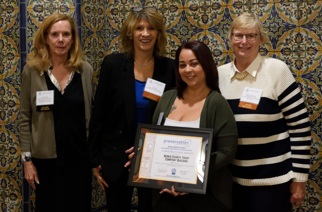 Jane Sheffield presenting the Rehabilitation Award for the Berks County Trust Company Building to Kelly Weir, Anna Ruiz, and Bonnie Wilkinson Mark
